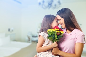 Canvas Print - Portrait of happy mother and daughter holding  flowers