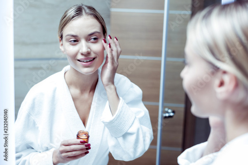 Fotografía Young good-looking woman putting some cream under her eyes