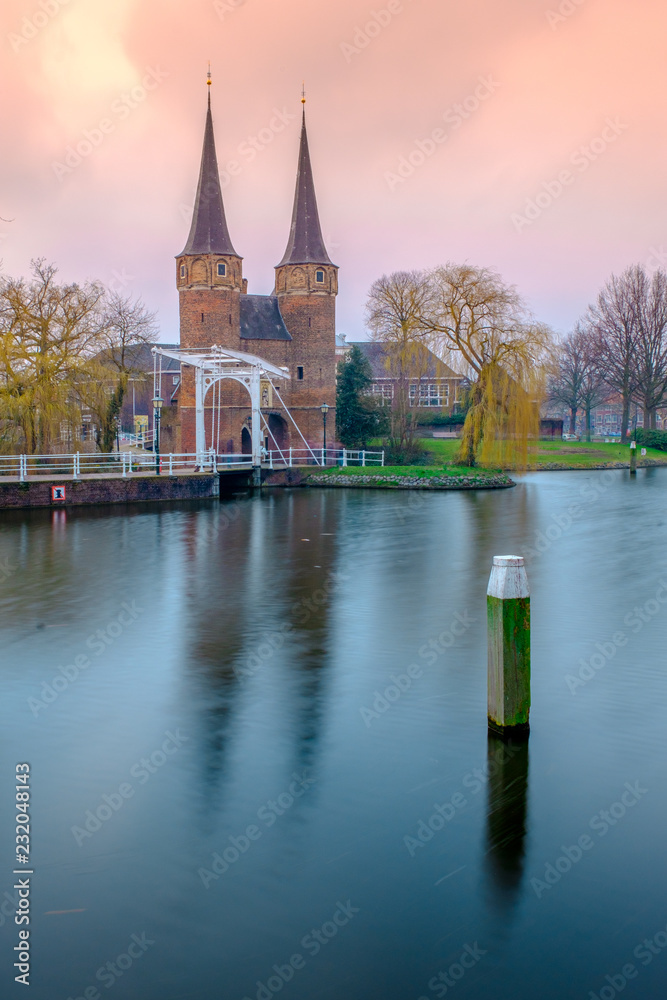 Evening view of the canal and the VVE Oostpoort de Delft. Dutch city in ...