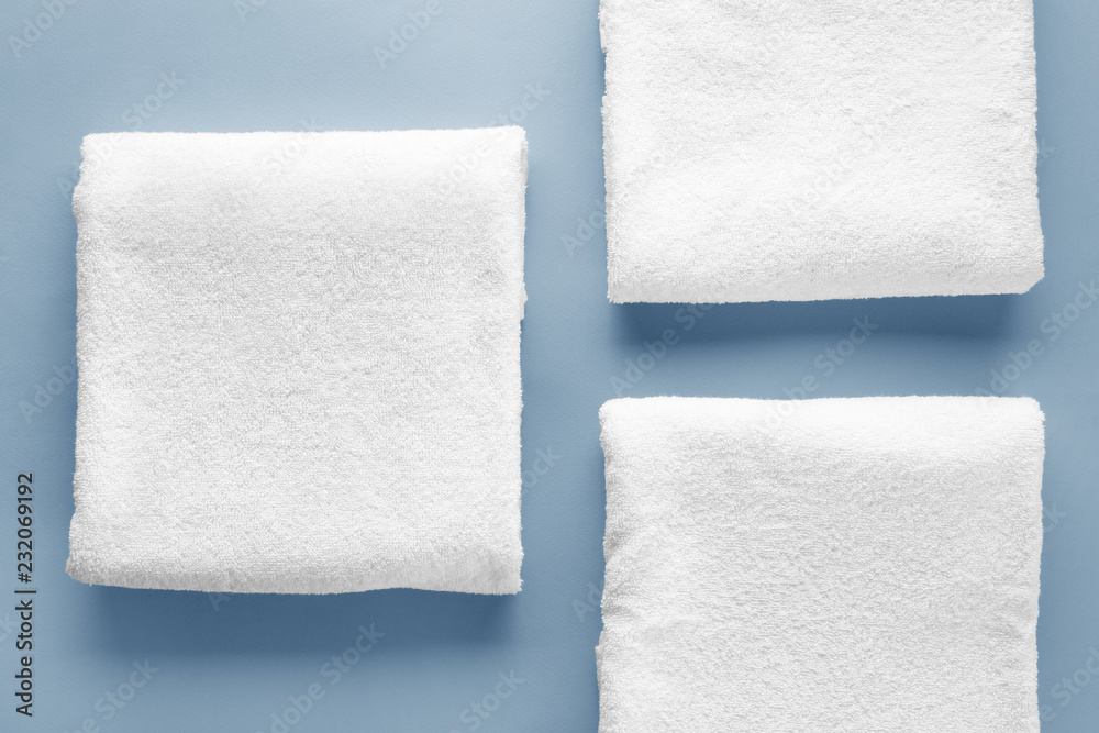 Clean soft towels on color background