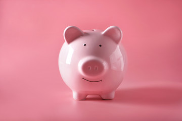 Ceramic piggy bank on color background