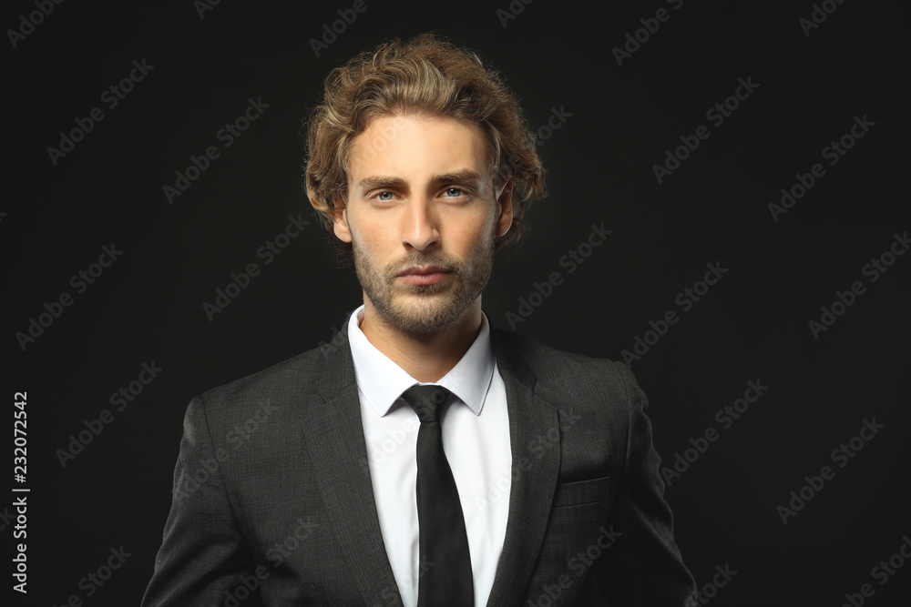 Portrait of successful businessman on black background