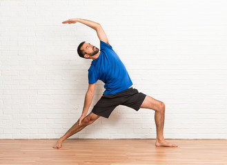 Man doing yoga exercises indoors