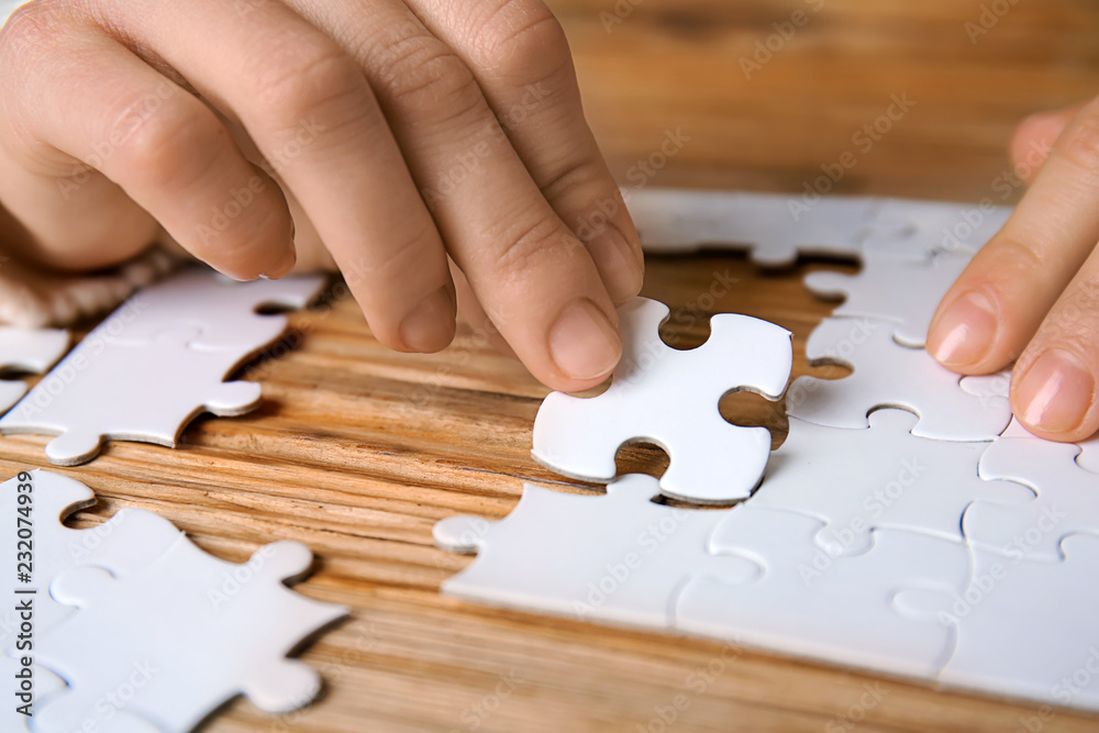Woman doing puzzle at table, closeup