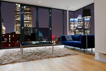 Modern living room with large windows and view on city panorama