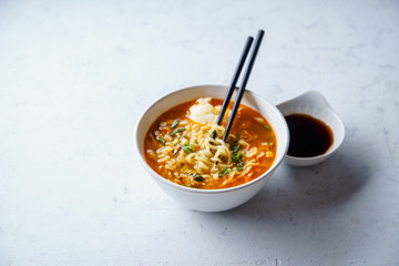 Easy japanese ramen with noodles, pork broth, egg and leek in white bowl on concrete background with copy space