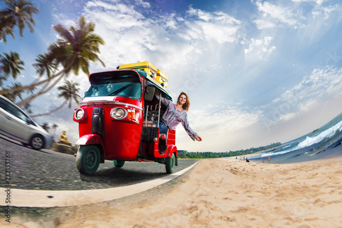 Valokuva Happy woman travel by traditional srilankan transport, road near beautiful sea a