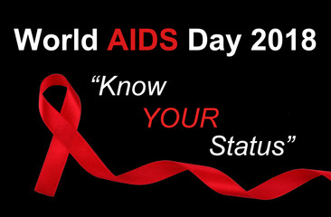World AIDS Day concept, red ribbon on black background with text 