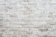 White painted brick wall full frame background with gritty textured imperfections