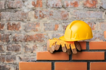 Yellow helmet with equipment on construction background