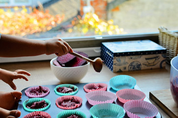 Muffin with spoon and little hand in the kitchen