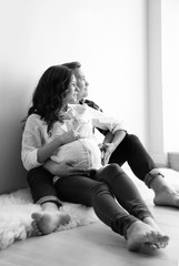 Poster - Pregnant woman with her husband indoors, black and white effect