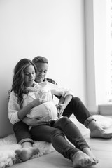 Poster - Pregnant woman with her husband indoors, black and white effect