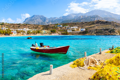 Fotografia Boat on sea in Lefkos port with fishing nets on shore, Karpathos island, Greece