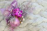 Fototapeta Storczyk - Background new year, Christmas. Christmas decoration, purple branch with balls and gift isolated on gray textured knitted background. Copy space. The festive side.