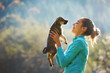 © vitaliymateha - young woman is playing with a cute little puppy on a green grass in the campsite