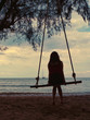 © Kavin - Girl on a swing is looking at the sea.
