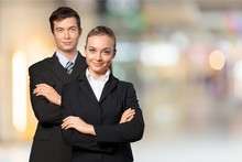 Two Confident Business People With Crossed Hands On Background