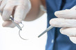 © allexxandarx - Doctor holding surgical forceps suture needle, suturing material