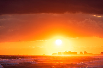 Wall Mural - Dramatic orange red sunset in Santa Rosa Beach, Florida with Pensacola coastline coast cityscape skyline in panhandle with ocean gulf mexico
