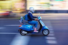 Young Woman With A Scooter On The Move In The City