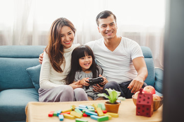 Happy Asian family lifestyle enjoy playing game and watching TV at home