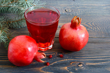 Wall Mural - Ripe pomegranate fruit and a glass of pomegranate juice on wooden table. Healthy eating concept.
