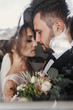 © sonyachny - Gorgeous bride and stylish groom gently hugging at window. Sensual wedding couple embracing. Romantic moments of newlyweds. Creative wedding photo through glass. Copy space