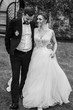 © sonyachny - Gorgeous bride and stylish groom holding hands and walking at wall of autumn red leaves. Happy Sensual wedding couple smiling. Romantic moments of newlyweds. Wedding photo