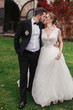 © sonyachny - Gorgeous bride and stylish groom gently hugging and kissing outdoors. Sensual wedding couple embracing. Romantic moments of newlyweds. Wedding photo