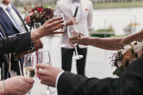 Hands Of People Holding Glasses Of Champagne And Toasting At