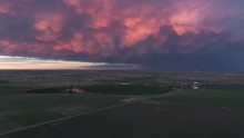 Mammatus Clouds Lit Up At Sunset Over Farm Land In Flat Landscape From Aerial View.