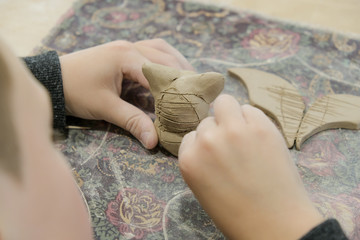 Wall Mural - A child molds a product from clay in a modeling lesson.