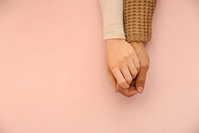 Loving Young Couple Holding Hands On Color Background
