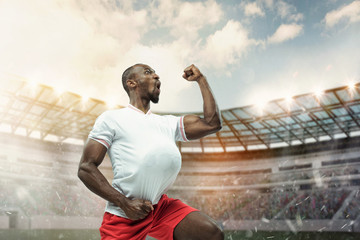 The football player in motion on the field of stadium