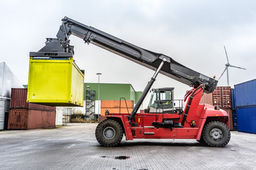 Wall Mural - Reach-Stacker carrying a yellow container