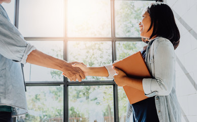 Business people shaking hands - businesswoman making handshake with a businessman.