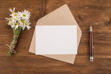Envelope, Pen And Flowers Daisy On A Wooden Background 
