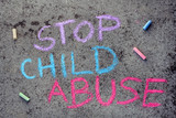 Fototapeta Tulipany - Colorful chalk drawing on asphalt: words STOP CHILD ABUSE