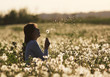 © MEDIAIMAG - Lady blowing dandelion fluff