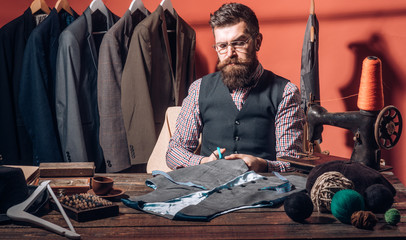 Working on new design. sewing mechanization. Bearded man tailor sewing jacket. suit store and fashion showroom. retro and modern tailoring workshop. business dress code. Handmade. Funky beauty