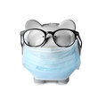 Piggy bank with glasses and face mask isolated on white