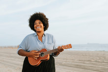 African American Musician Playing Ukulele At The Beach