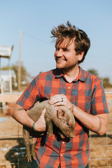 Happy young man with a piglet