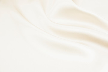 The texture of the satin fabric of beige color for the background 