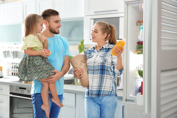 Sticker - Happy family putting products into refrigerator in kitchen