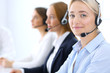 © rogerphoto - Call center. Group of operators at work. Focus at blonde business woman in headset