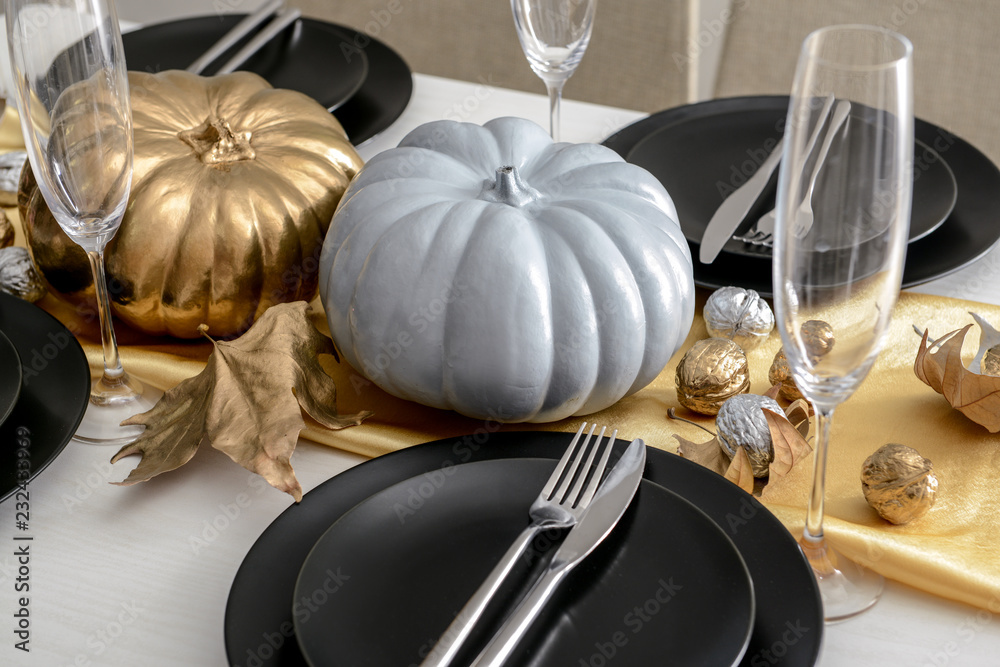 Stylish table setting with painted pumpkins