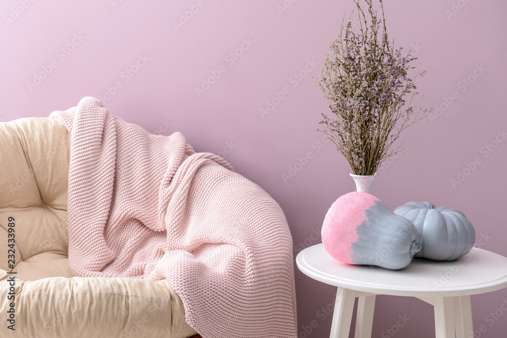 Painted pumpkins on white table in interior of room