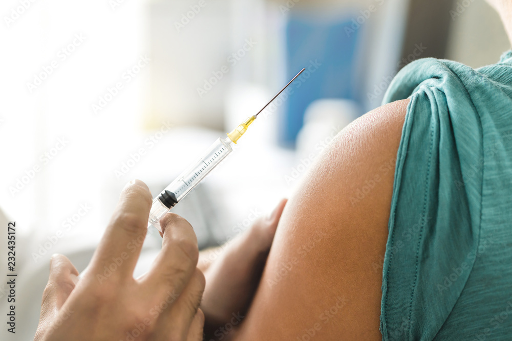 Vaccine or flu shot in injection needle. Doctor working with patient's arm. Physician or nurse giving vaccination and immunity to virus, influenza or HPV with syringe. Appointment with medical expert. - obrazy, fototapety, plakaty 